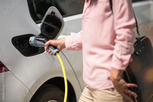 Woman charging electric car 