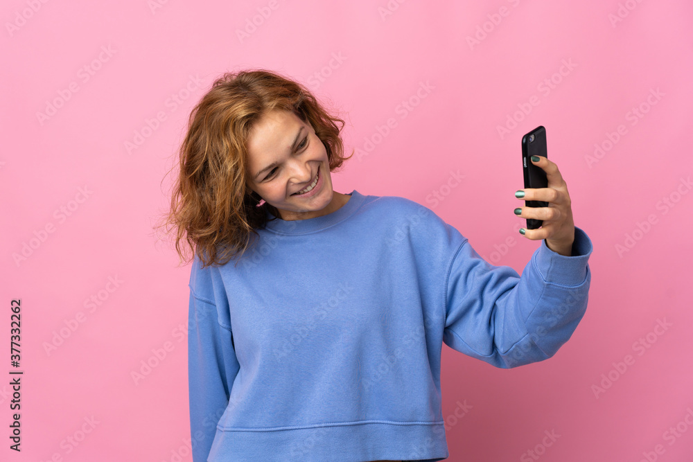 Young Georgian woman isolated on pink background making a selfie Young Georgian woman isolated on pink background making a selfie