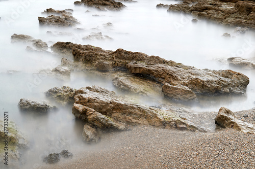 Long exposure photography with a neutral density filter. Beach in Asturias, Spain with a cloudy sunrise.