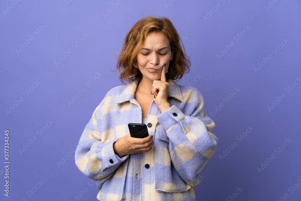Young Georgian woman isolated on purple background thinking and sending a message Young Georgian woman isolated on purple background thinking and sending a message