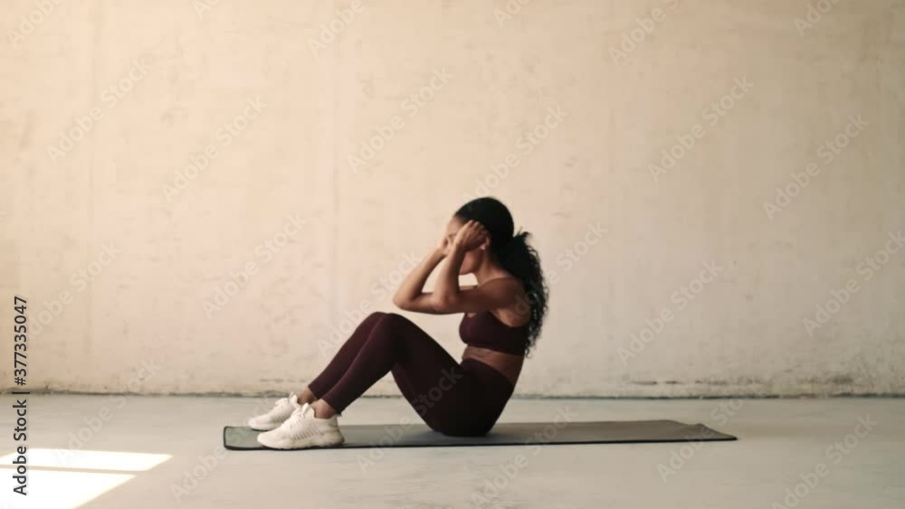 Young african fitness woman making sport abs exercises isolated over white wall background Young african fitness woman making sport abs exercises isolated over white wall background