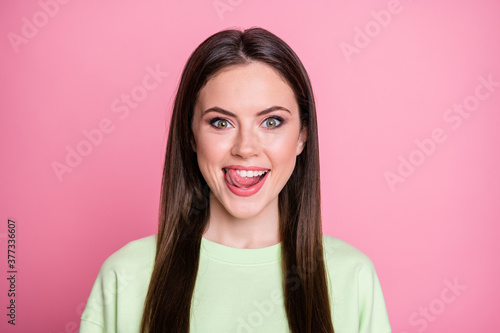 Closeup photo of funny attractive lady straight long hairdo funny girlish licking lips tongue see tasty dessert wear casual green sweatshirt pullover isolated pink color background © deagreez