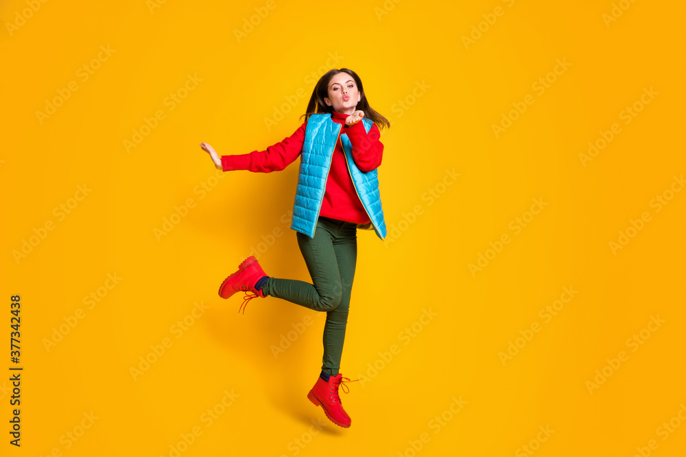 Full length photo charming girl jump hold hand send lovely air kiss boyfriend buy present fall season sales wear stylish green blue red sweater boots isolated bright shine color background Full length photo charming girl jump hold hand send lovely air kiss boyfriend buy present fall season sales wear stylish green blue red sweater boots isolated bright shine color background