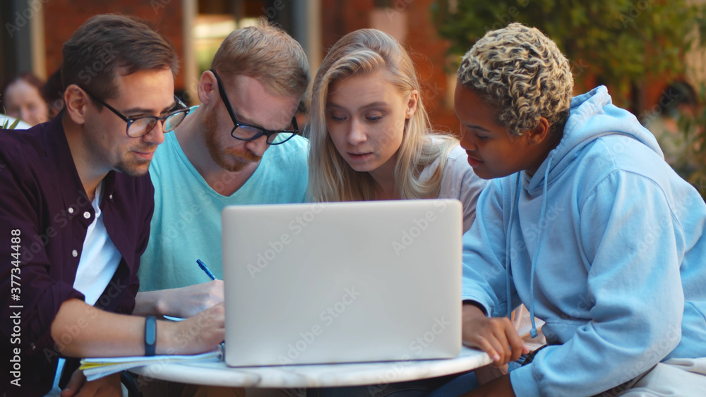 Portrait of University students studying together and using laptop outdoors the university campus. Portrait of University students studying together and using laptop outdoors the university campus.