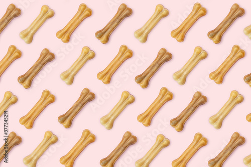 Pink background of dog goodies in the form of a bone.