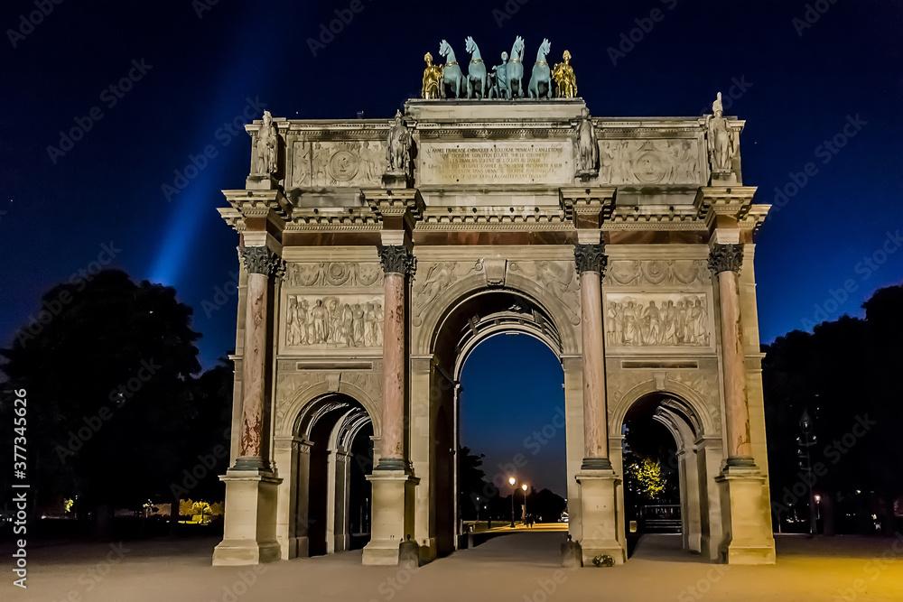 Fototapeta premium Triumphal Arch (Arc de Triomphe du Carrousel) at night in Tuileries gardens in Paris. Monument built between 1806 - 1808 to commemorate Napoleon's military victories. Paris, France.