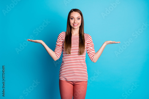 Photo of positive cheerful girl promoter hold hand demonstrate compare measure adverts promo wear look good outfit isolated over blue color background