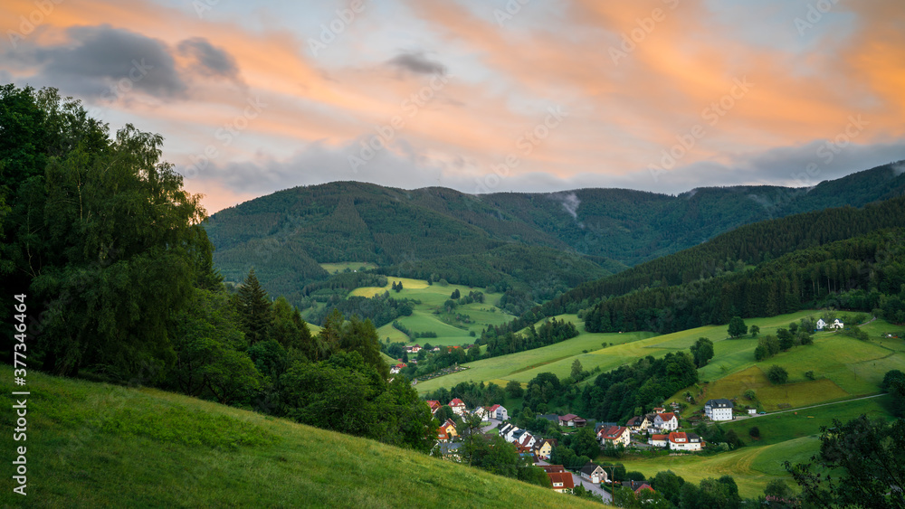 Germany, Black Forest Schwarzwald, Glowing red sky above green valley and village in elztal in summer