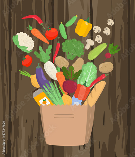 Paper bag full of food on wooden background.