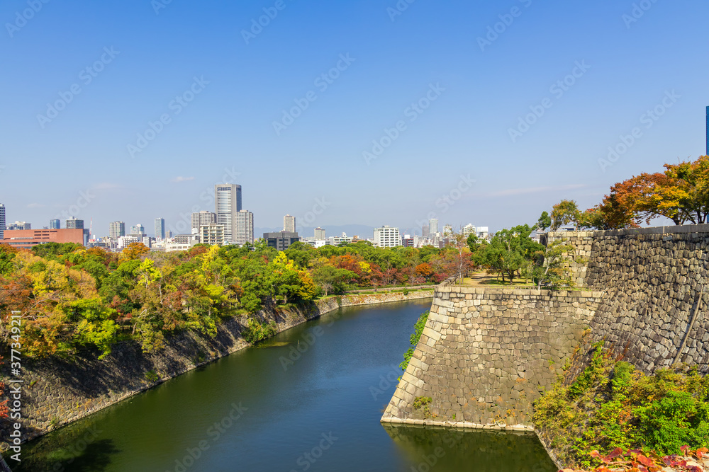 Beautiful cityscape at autumn,colorful woods and moat and old style city wall, the Osaka Castle Park,Osaka,Japan