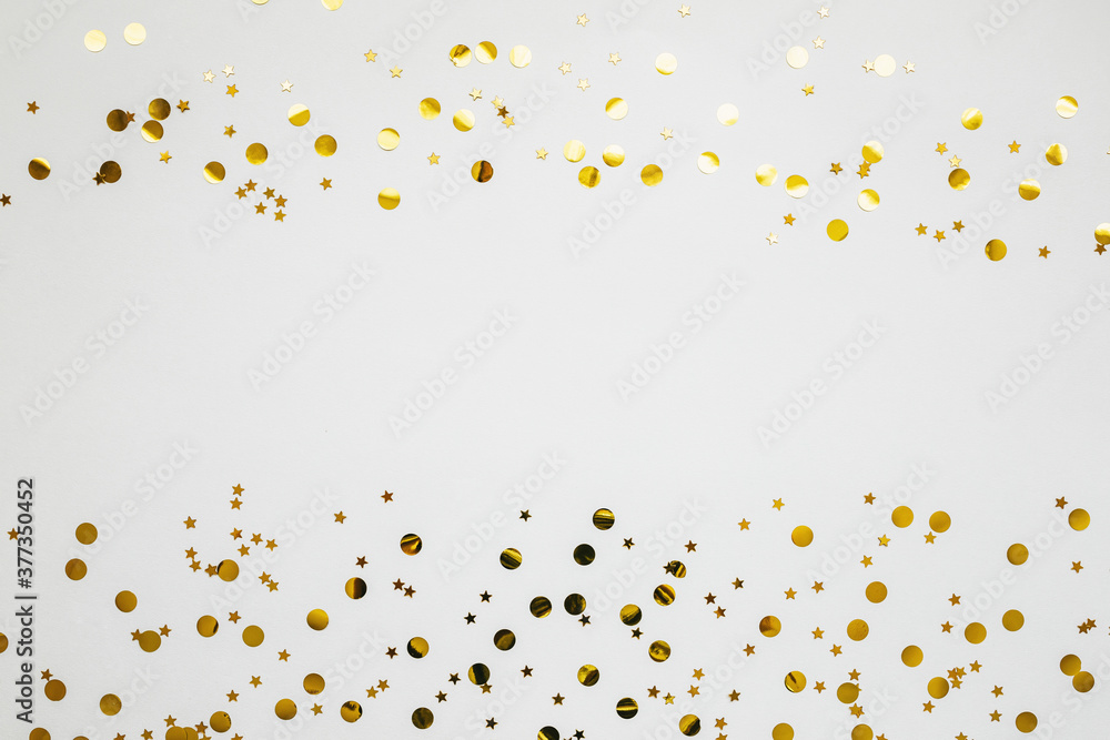 Gold and silver confetti on a white festive background. In the middle there is space for text or copy space.