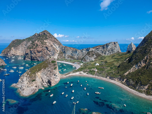 Drone view of Palmarola island with chrystalline green water and boats (Ponza, Latina, Lazio, Italy).