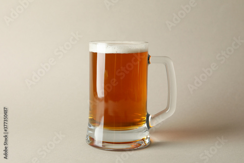 Glass of beer on gray background, space for text