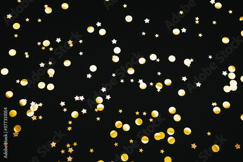 Gold confetti on a black festive background.