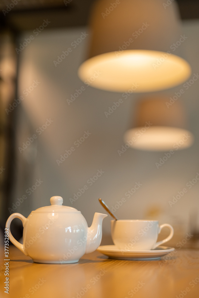 teapot and a white cups on the wooden table