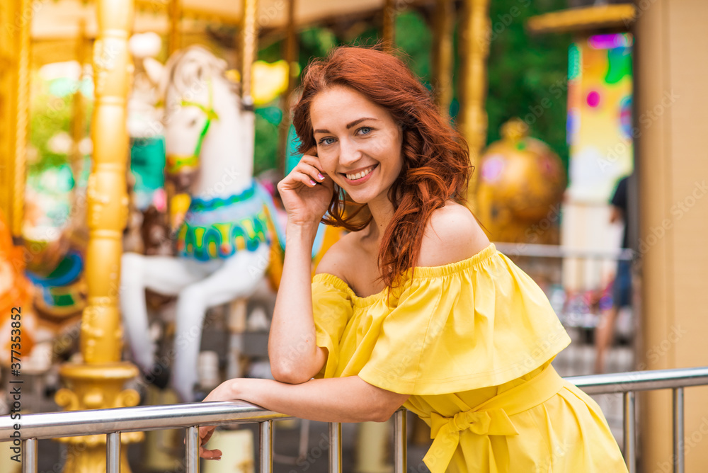 Obraz premium Happy beautiful redhead girl walking in the park