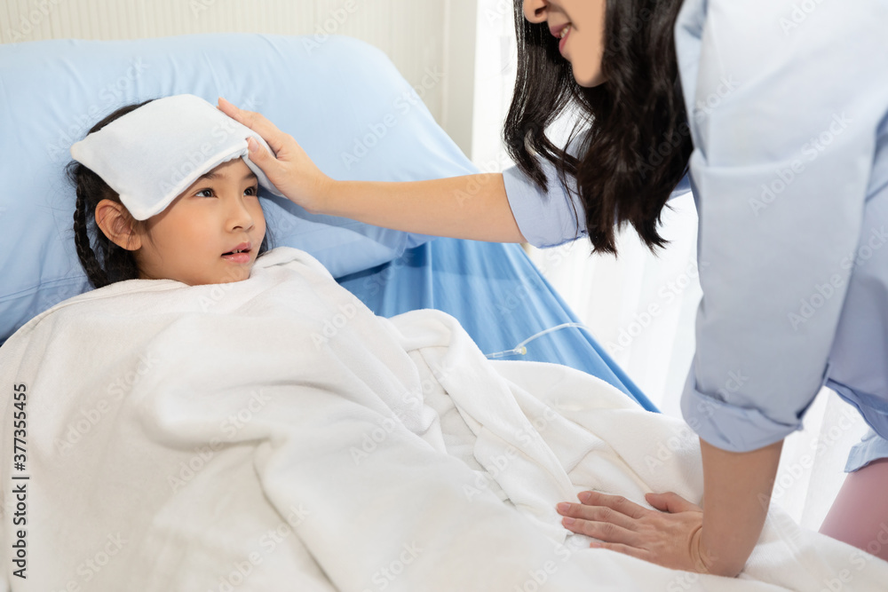 close up asian girl have a fever, she's lying on bed in hospital with her mother support and watched her closely close up asian girl have a fever, she's lying on bed in hospital with her mother support and watched her closely