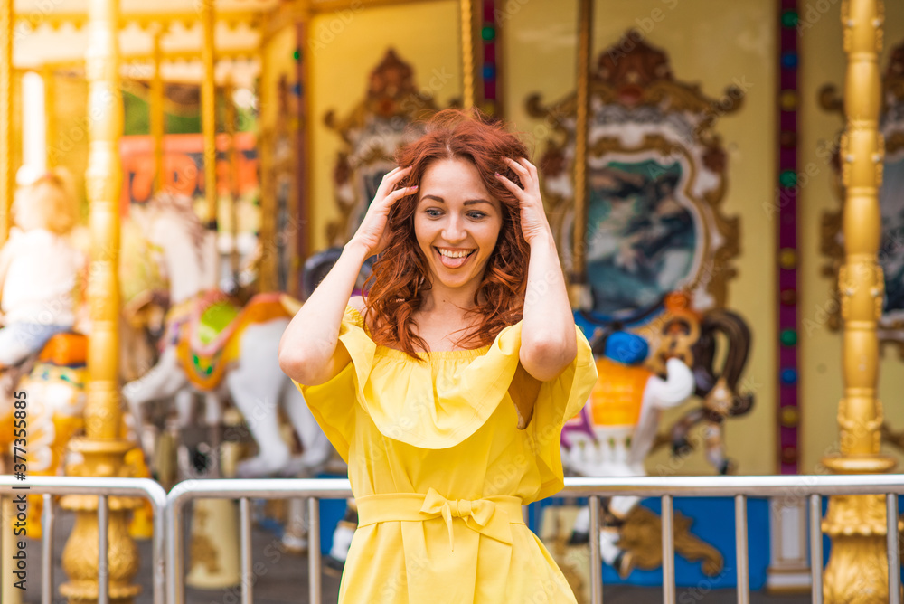 Fototapeta premium Happy beautiful redhead girl walking in the park
