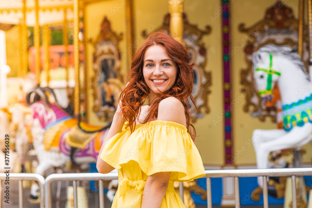 Obraz premium Happy beautiful redhead girl walking in the park
