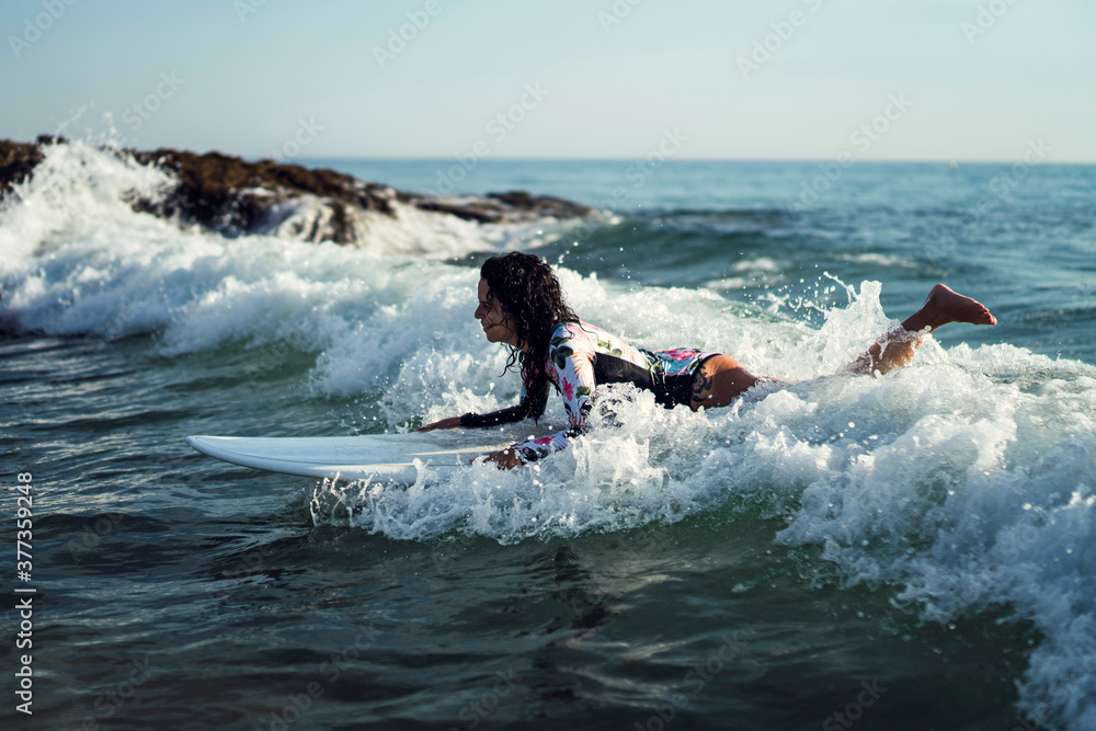 Joven atractiva con tabla de surf practicando en cadiz