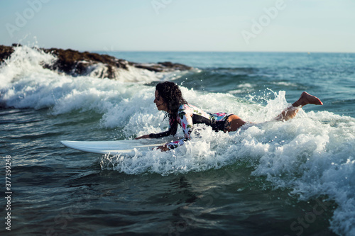 Joven atractiva con tabla de surf practicando en cadiz