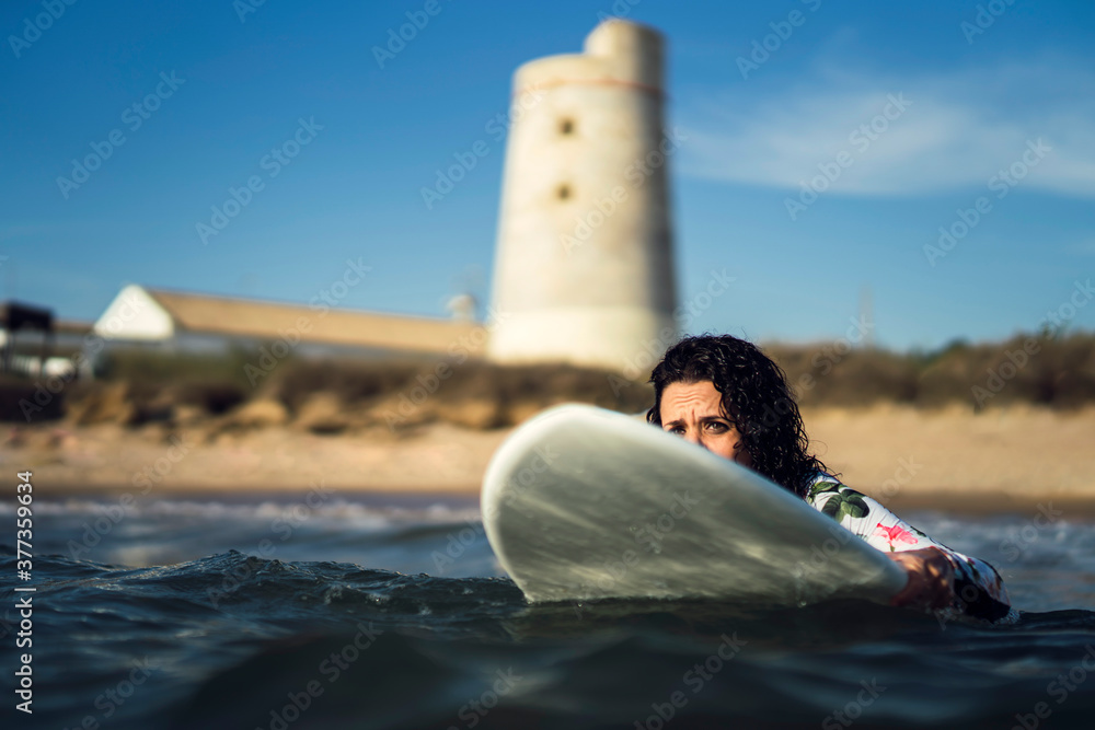 Naklejka premium Joven atractiva con tabla de surf practicando en cadiz