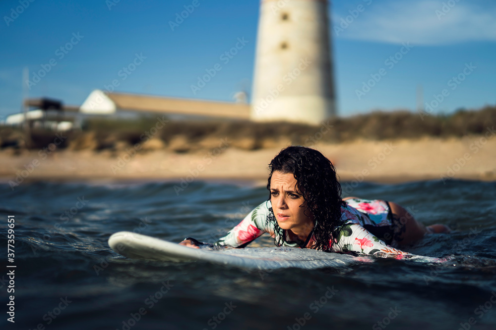 Obraz premium Joven atractiva con tabla de surf practicando en cadiz