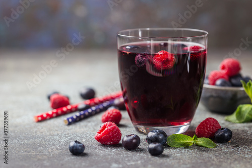 Berry drink with fresh blueberries and raspberries, berry ice lemonade in a glass