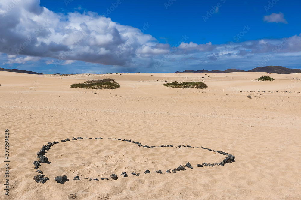 Romantico corazon hecho en la arena con rocas volcanicas de la isla de Fuerteventura, Islas Canarias, España Romantico corazon hecho en la arena con rocas volcanicas de la isla de Fuerteventura, Islas Canarias, España