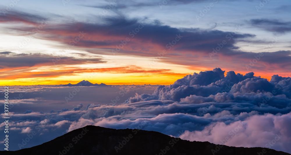 Fototapeta premium Beautiful cloudscape with Mt. Rinjani at the horizon. View from Mt. Agung at sunrise. Bali, Indonesia.