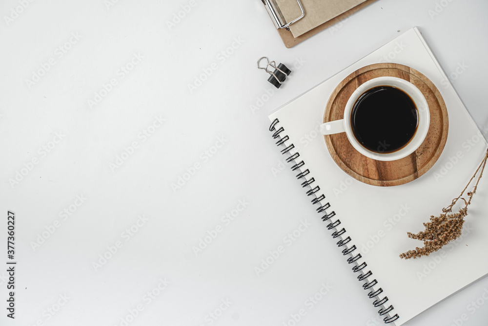 Workplace in office with white desk. Top view from above of keyboard with notebook and coffee. Space for modern creative work of designer. Flat lay with blank copy space.