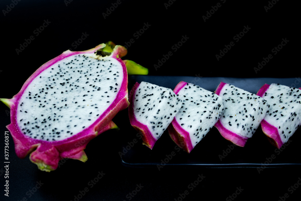 half of dragonfruit on black background and triangle slice half of dragonfruit on black background and triangle slice