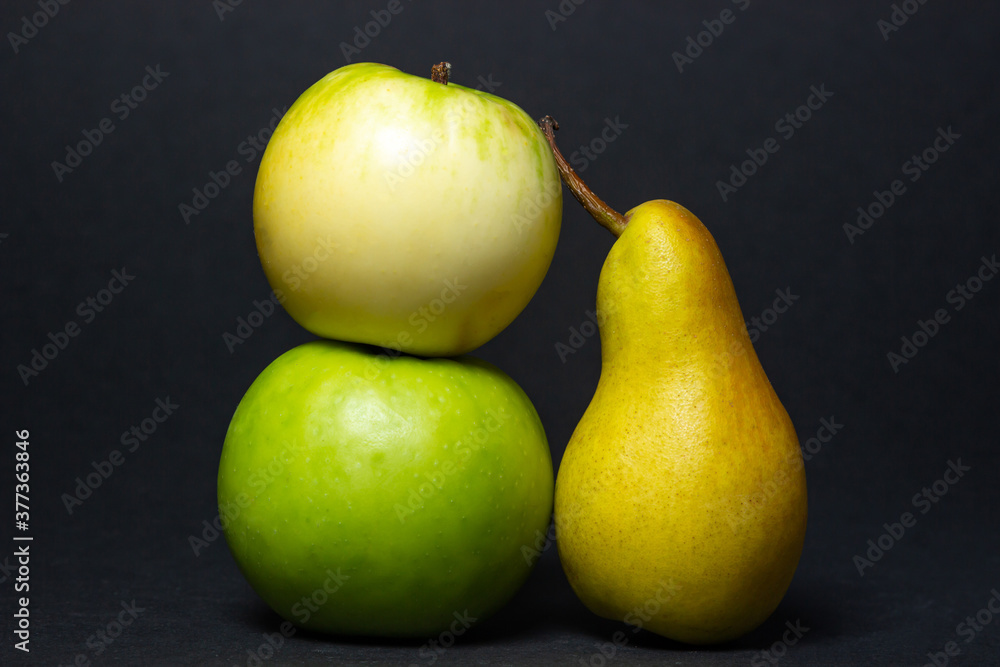 Fruit on a black background. Pear and apples are next to each other. Healthy fruits Fruit on a black background. Pear and apples are next to each other. Healthy fruits