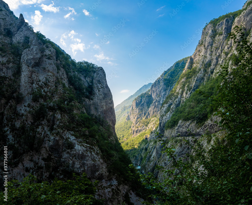 Obraz premium Mochara river canyon in montenegro, high steep mountains and cliffs with dawn rays of the sun, tourism in europe and the balkan peninsula