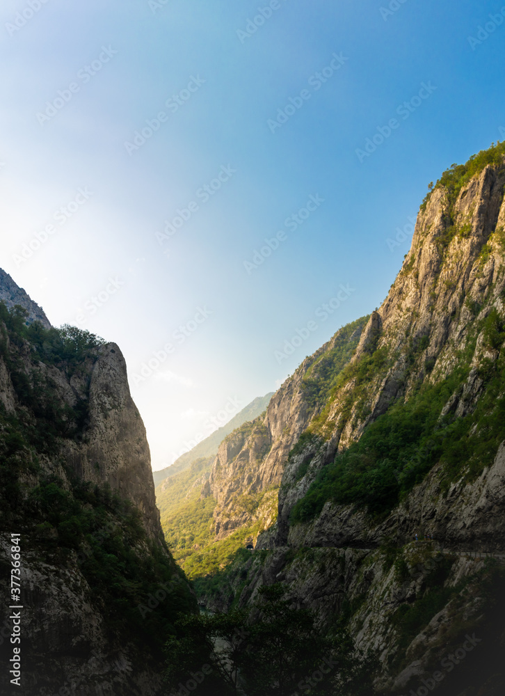 Mochara river canyon in montenegro, high steep mountains and cliffs with dawn rays of the sun, tourism in europe and the balkan peninsula