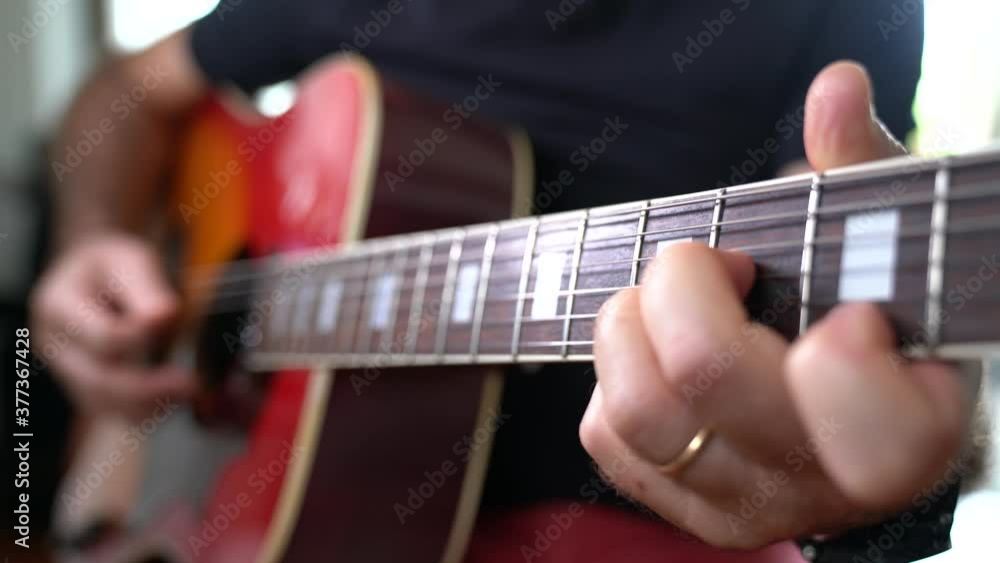 MANI DI UOMO ADULTO SUONANO LA CHITARRA ACUSTICA ARPEGGIANDO ESEGUENDO NOTE MUSICALI MANI DI UOMO ADULTO SUONANO LA CHITARRA ACUSTICA ARPEGGIANDO ESEGUENDO NOTE MUSICALI