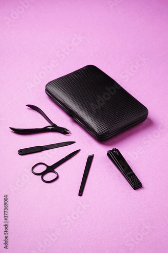 Fototapeta Naklejka Na Ścianę i Meble -  Set of manicure and pedicure tools and accessories near to case, angle view, pink background