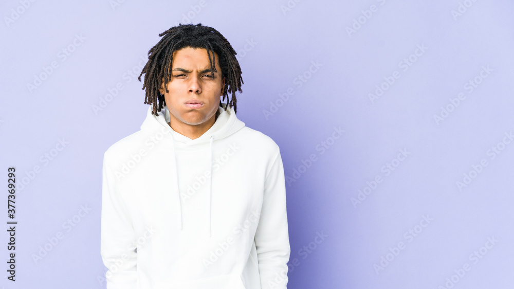 Young african american rasta man blows cheeks, has tired expression. Facial expression concept. Young african american rasta man blows cheeks, has tired expression. Facial expression concept.