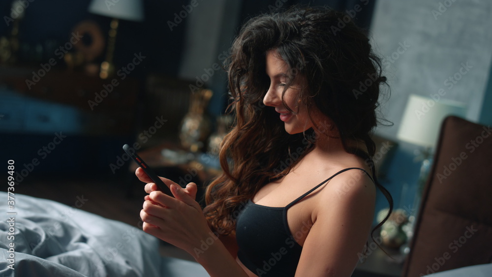 © stockbusters - Hot woman taking seductive poses in bed. Gorgeous girl using phone in bedroom. © stockbusters - Hot woman taking seductive poses in bed. Gorgeous girl using phone in bedroom.