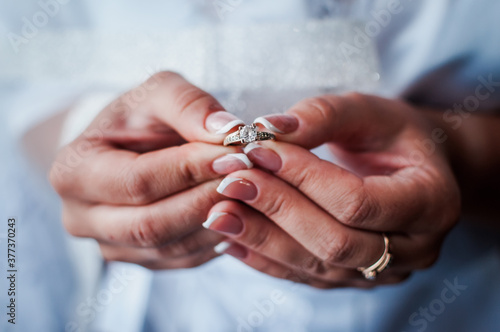 the bride holds a gold ring in her hands