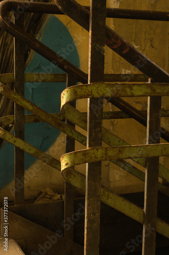 An old style metal bannister on an industrial stairwell.