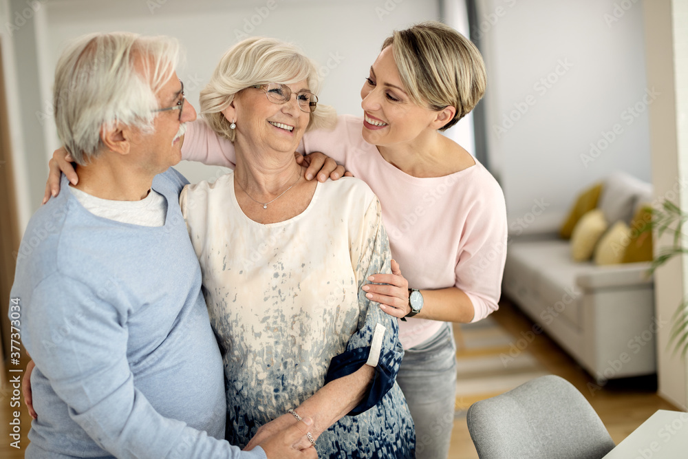 Happy senior couple talking to their adult daughter at home. Happy senior couple talking to their adult daughter at home.
