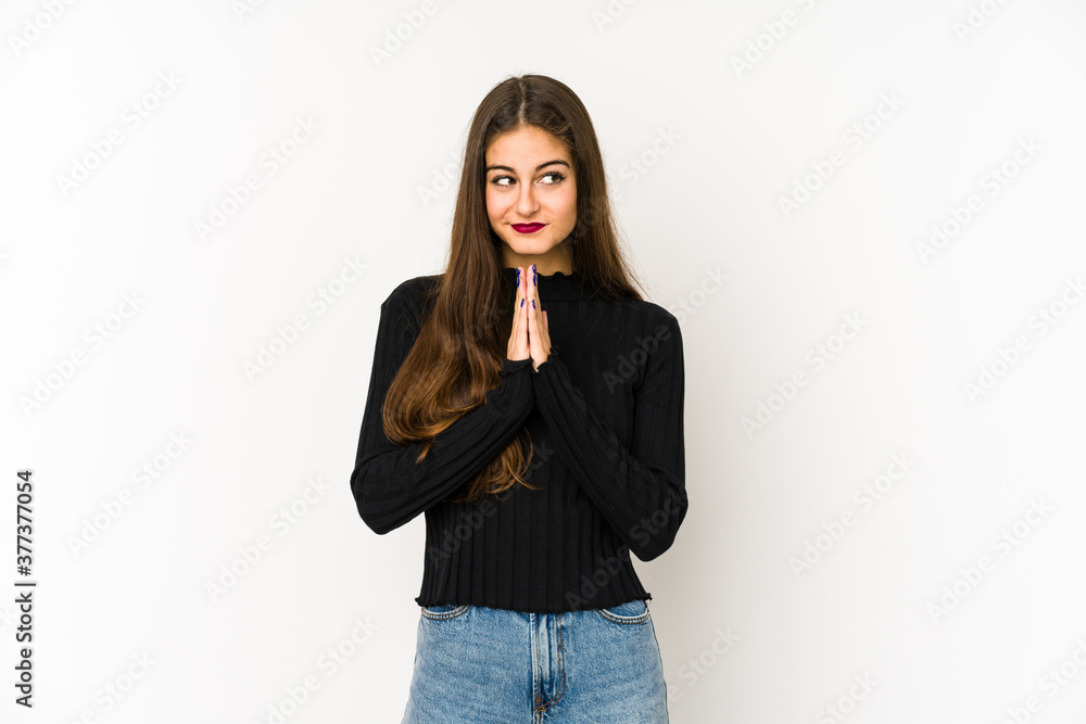 Young caucasian woman isolated on white background praying, showing devotion, religious person looking for divine inspiration. Young caucasian woman isolated on white background praying, showing devotion, religious person looking for divine inspiration.