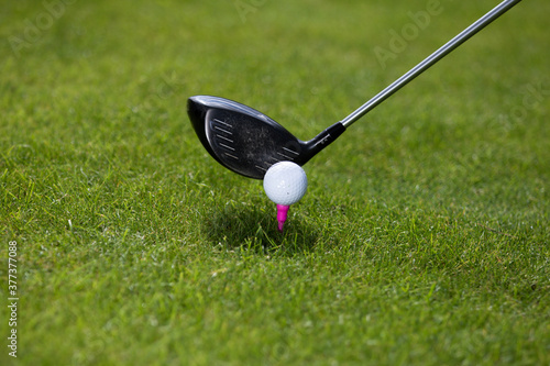 A golfer prepares to hit the ball with a driver