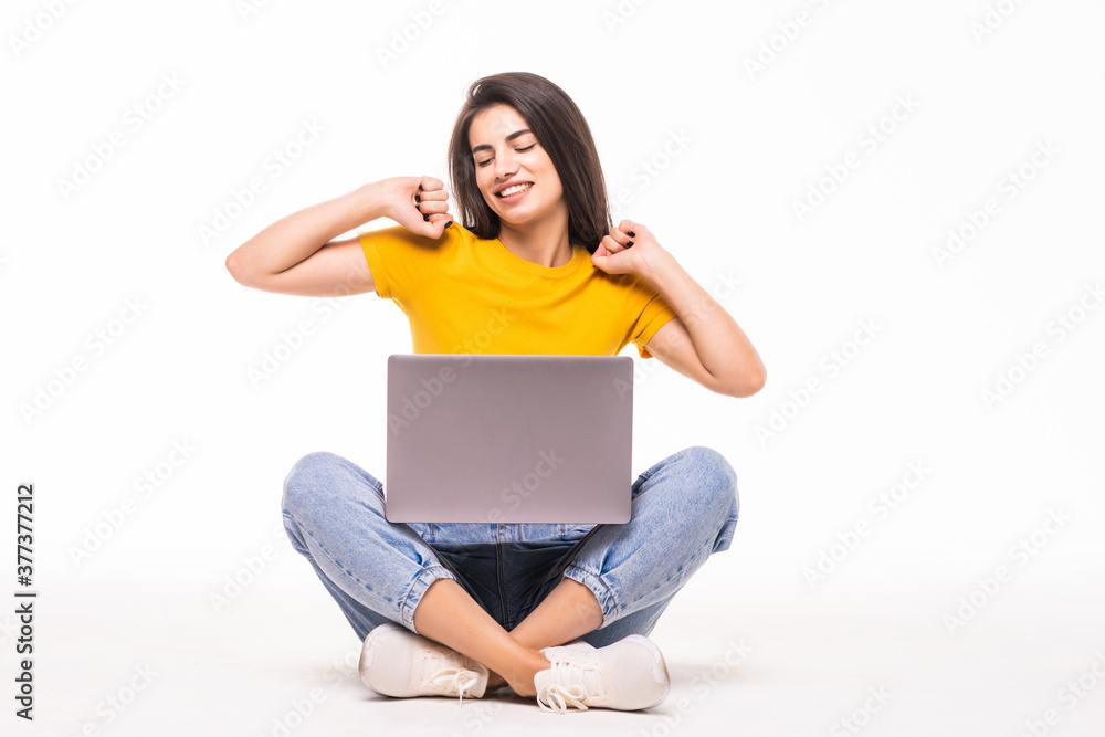 Young woman sitting on the floor with a laptop computer and arms up isolated on white background Young woman sitting on the floor with a laptop computer and arms up isolated on white background
