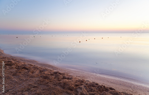 Stunning sea sunrise with calm tranquil sea ang magnificient purple sky.