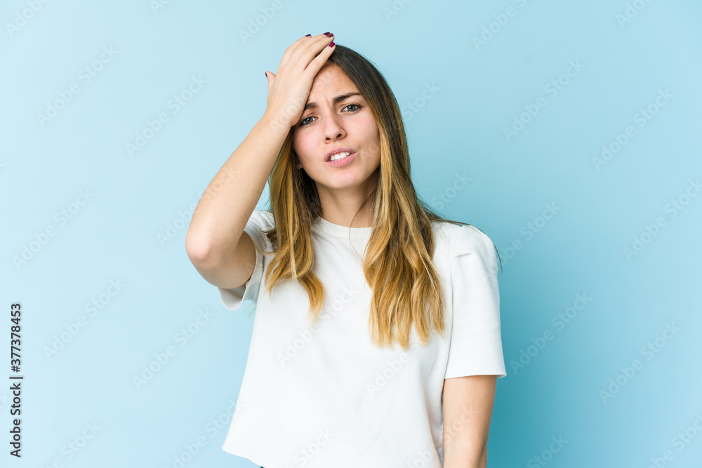 Young caucasian woman isolated on blue background forgetting something, slapping forehead with palm and closing eyes. Young caucasian woman isolated on blue background forgetting something, slapping forehead with palm and closing eyes.