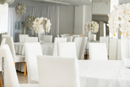 Empty restaurant luxury interior background. Empty chair and table inside room photo. White restaurant interior.