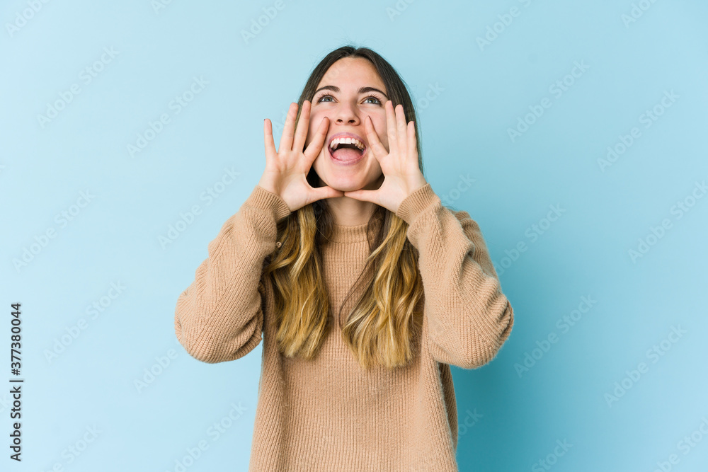 Young caucasian woman isolated on blue background shouting excited to front. Young caucasian woman isolated on blue background shouting excited to front.