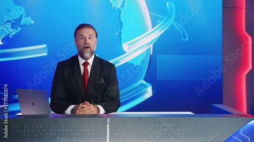 Live News Studio with Professional Male Newscaster Reporting on the Events of the Day. TV Broadcasting Channel with Presenter, Anchor Talking. Mock-up Television Channel Newsroom Set photo